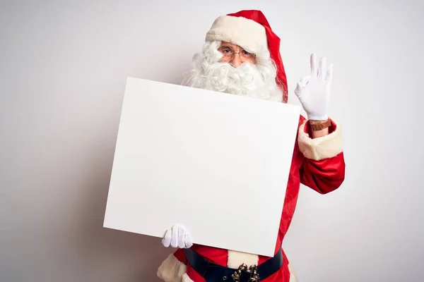 中年男人穿着圣诞老人的服装 拿着横幅挂在孤立的白色背景上 手握大旗 手握大指 做着很好的标志 — 图库照片