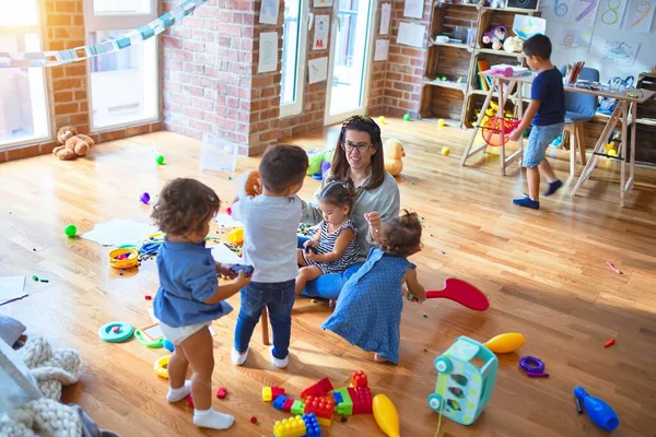 Mooie Leraar Groep Peuters Spelen Rond Veel Speelgoed Kleuterschool — Stockfoto