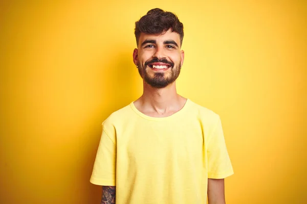 Молодий Чоловік Татуюванням Футболці Стоїть Над Ізольованим Жовтим Тлом Щасливою — стокове фото