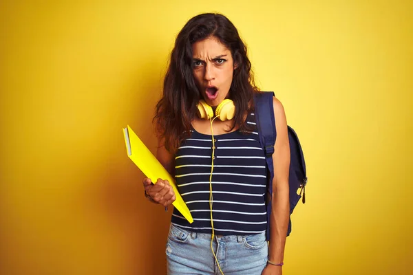 Studentin Mit Bakcpack Notizbuch Kopfhörer Über Isoliertem Gelbem Hintergrund Erschrocken — Stockfoto