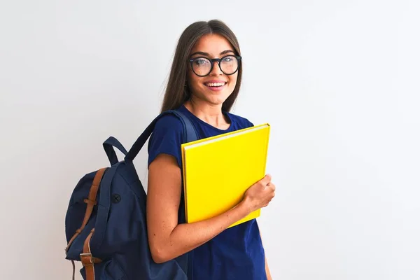 Young student woman wearing backpack glasses holding book over isolated white background with a happy face standing and smiling with a confident smile showing teeth