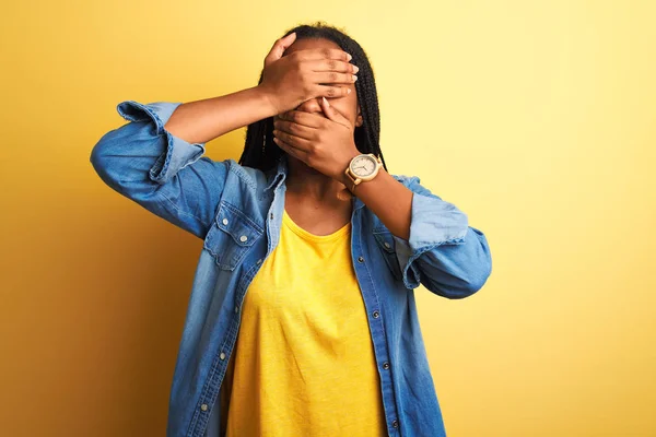 Молодая Африканская Американка Джинсовой Рубашке Стоящая Изолированном Желтом Фоне Закрывая — стоковое фото