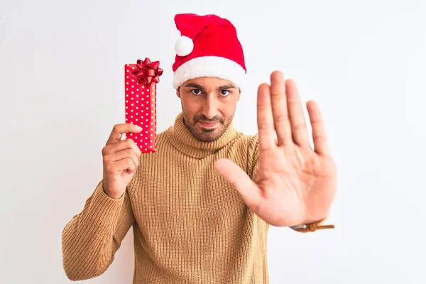 Junger Gutaussehender Mann Trägt Weihnachtsmütze Und Hält Geschenk Über Isoliertem — Stockfoto