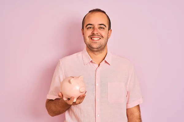 Joven Sosteniendo Piggybank Pie Sobre Fondo Rosa Aislado Con Una — Foto de Stock