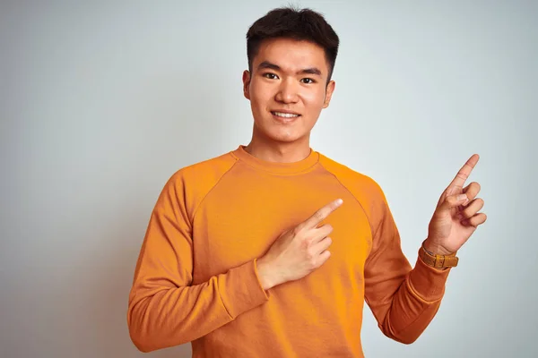 Joven Asiático Chino Hombre Usando Naranja Suéter Pie Sobre Aislado —  Fotos de Stock