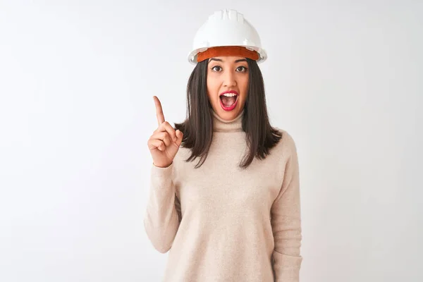 年轻的中国建筑师女人戴着安全帽 站在孤立的白色背景上 指指点点着成功的点子 又兴奋又快乐 第一部分 — 图库照片