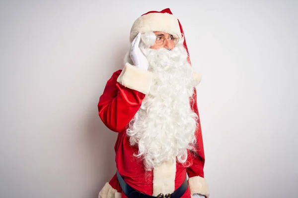 中年男子穿着圣诞老人的服装 站在孤立的白色背景上 面带微笑 两手空空地听着谣言或闲话 失聪的概念 — 图库照片