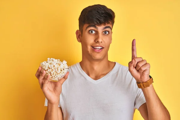 Young Indian Man Holding Pack Popcorn Standing Isolated Yellow Background — Stock Photo, Image