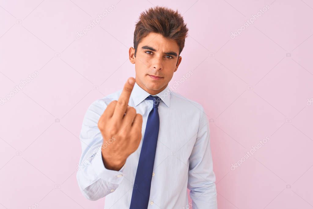 Young handsome businessman wearing shirt and tie standing over isolated pink background Showing middle finger, impolite and rude fuck off expression