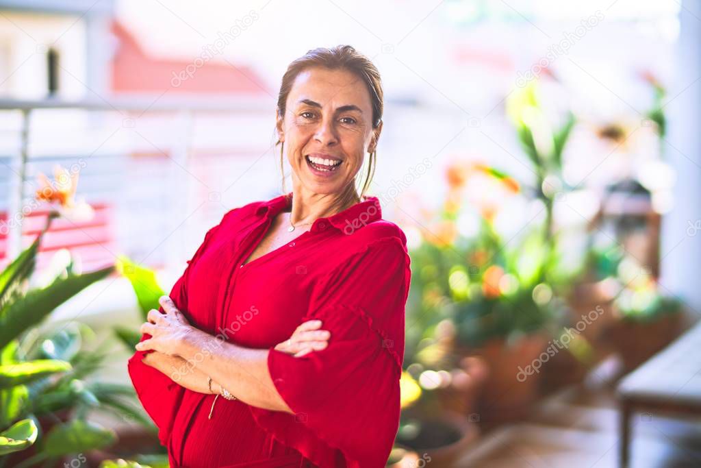 Middle age beautiful woman smiling happy and confident standing with a smile on face at terrace