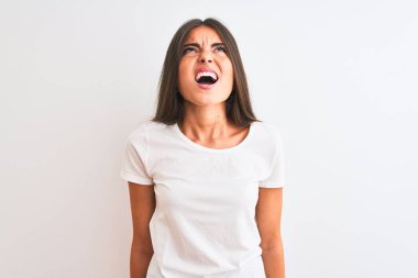 Genç, güzel bir kadın, izole edilmiş beyaz arka plan üzerinde dikilmiş sinirli ve öfkeli bir şekilde bağıran, öfkeyle bağıran bir tişört giyiyor. Öfke ve agresif kavram.