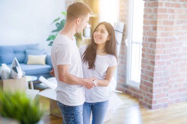 Karton kutular etrafında yeni evde sarılma genç güzel çift