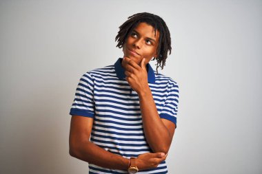 Sarı çizgili mavi polo giyen Afro bir adam izole edilmiş beyaz arka planda duruyor. Kameraya bakıyor ve kollarını kavuşturup ellerini çenesine kaldırarak gülümsüyor. Olumlu düşünüyorum..