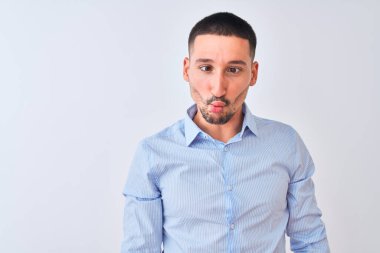Genç yakışıklı iş adamı izole edilmiş arka planda duruyor dudaklarıyla balık suratı yapıyor, çılgınca ve komik bir jest. Komik ifade.