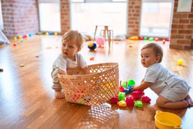 Anaokulunda bir sürü oyuncakla oynayan güzel çocuklar.