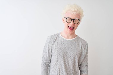 Genç albino sarışın adam çizgili tişört ve gözlük takıyor izole edilmiş beyaz arka plan üzerine komik bir ifadeyle dilini dışarı çıkarıyor. Duygu kavramı.