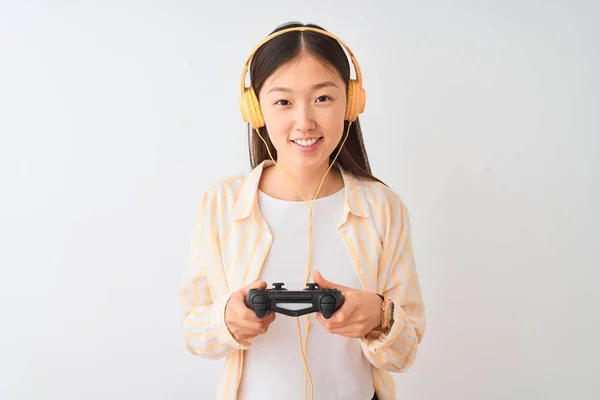 中国游戏女玩家用耳机在孤立的白色背景下玩电子游戏 脸上挂着快乐的表情 脸上挂着自信的微笑 露出牙齿 — 图库照片