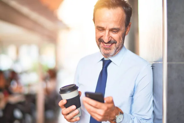 Střední Věk Hezký Podnikatel Pomocí Smartphone Pití Odnést Kávu Úsměvem — Stock fotografie