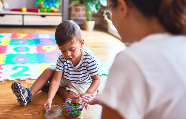 Красивий Вчитель Малюк Сидить Їдячи Маленькі Шоколадні Кульки Дитячому Садку — стокове фото