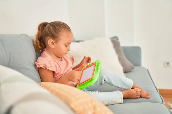 Schöne Blonde Kleinkind Mädchen Sitzt Auf Dem Sofa Zeichnung Mit — Stockfoto