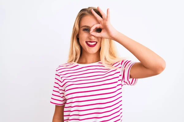年轻美丽的女人穿着粉色条纹T恤 站在孤零零的白色背景上 做着一个手势 脸上挂着微笑 用手指看着 面带笑容 — 图库照片