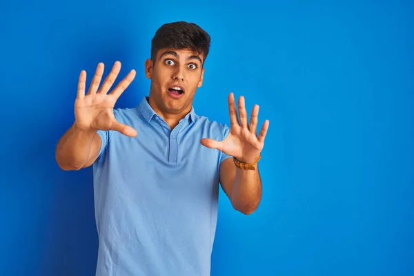 孤立した青の背景の上に立つカジュアルなポロを身に着けている若いインド人男性は ショックで叫んで 手で恐怖表現を停止ジェスチャーで恐れている パニック概念 — ストック写真