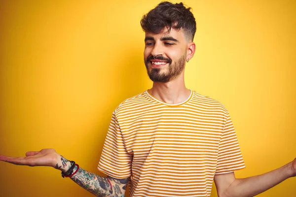 Junger Mann Mit Tätowierung Gestreiftem Shirt Vor Isoliertem Gelben Hintergrund — Stockfoto