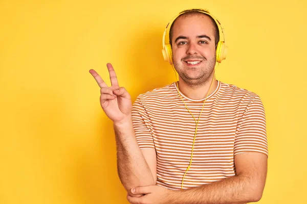 Joven Escuchando Música Usando Auriculares Parados Sobre Fondo Amarillo Aislado —  Fotos de Stock