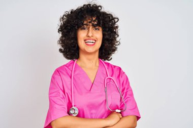 Genç Arap doktor, kıvırcık saçlı, steteskop takan, izole edilmiş beyaz arka planda mutlu, kollarını kavuşturup kameraya bakan kadın. Pozitif kişi.