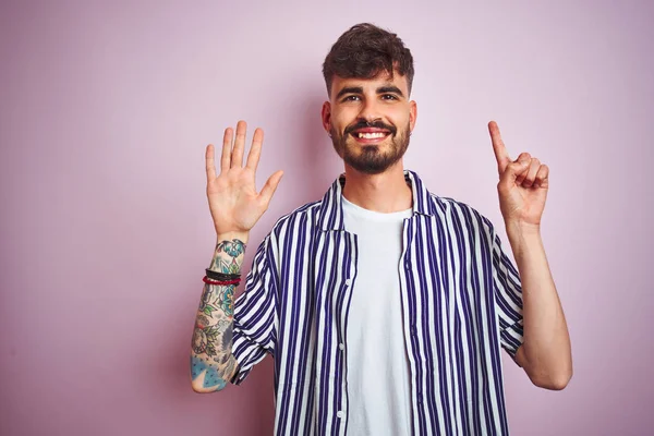 Mladý Muž Tetováním Sobě Pruhovanou Košili Stojící Nad Izolované Růžové — Stock fotografie