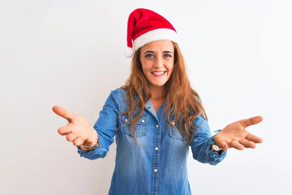 若いです美しいです赤毛女性身に着けていますクリスマス帽子上の隔離された背景笑顔陽気に提供手援助と受け入れ — ストック写真