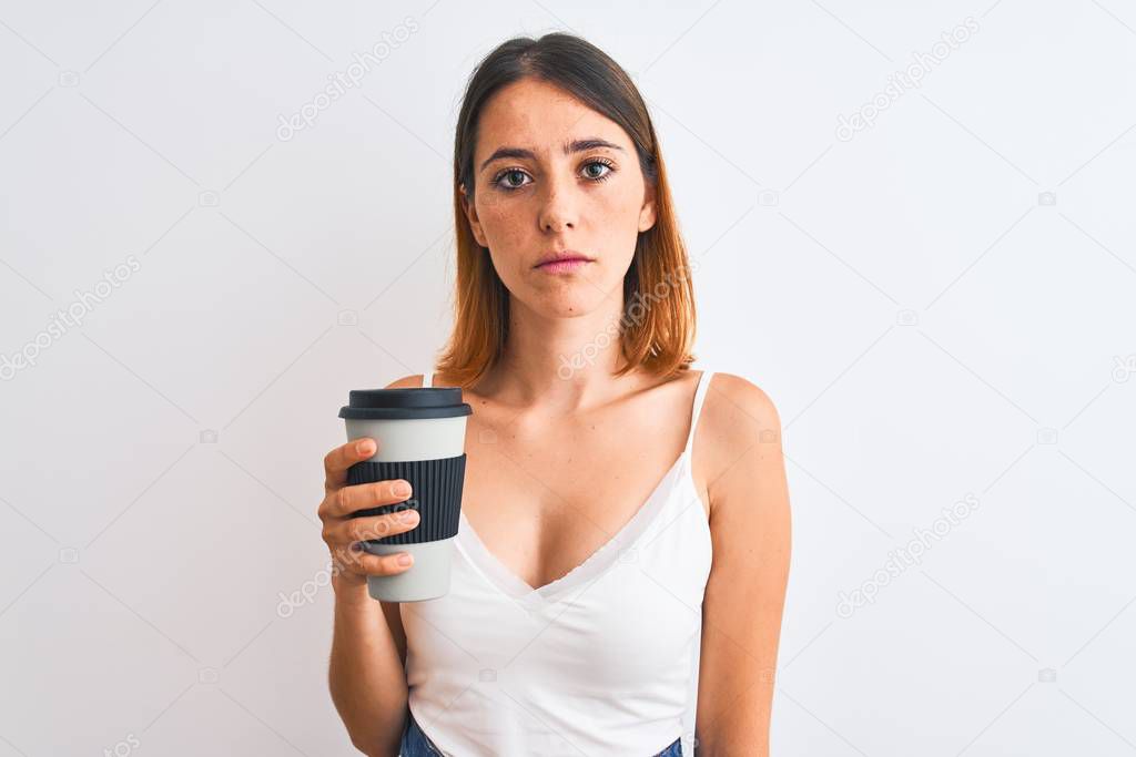 Beautiful redhead woman drinking take away coffee over isolated background with a confident expression on smart face thinking serious