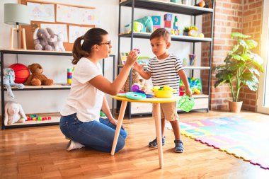 Anaokulunda plastik tabaklar, meyveler ve sebzelerle oynayan güzel çocuk.