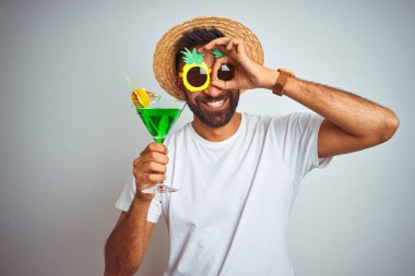 Yazın komik giyinen Hintli adam gülen yüzlü, izole beyaz arka planda kokteyl içiyor.