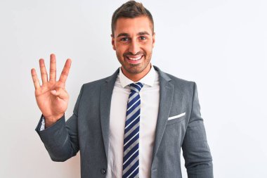 Takım elbiseli ve kravatlı genç yakışıklı bir iş adamı dört numarayı gösterip işaret ederken kendinden emin ve mutlu gülümsüyor..