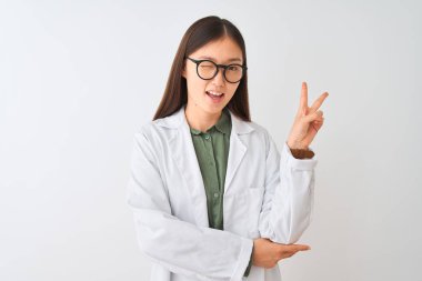 Kürk ve gözlük takan genç Çinli bilim kadını izole edilmiş beyaz arka planda gülümseyen ve kameraya gülümseyen zafer işareti yapan. İki numara..