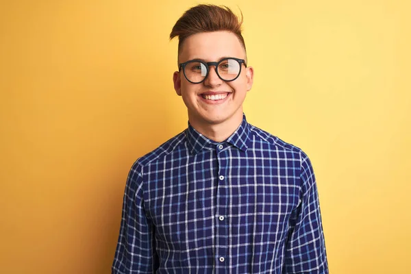 幸せとクールな笑顔で 孤立した黄色の背景の上にカジュアルなシャツと眼鏡を身に着けている若いハンサムな男 運のいい人 — ストック写真