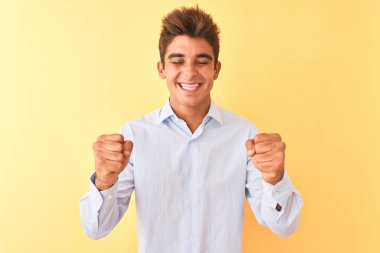 Yakışıklı genç işadamı zarif gömlekler giyerek başarı için heyecanlı kolları havada ve gözleri kapalı zaferi kutlarken gülümsüyor. Kazanan konsept.