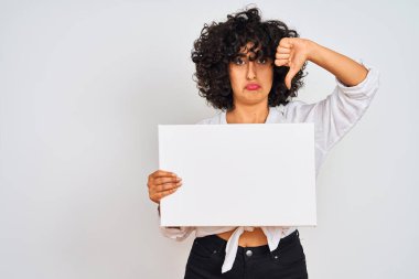 Genç, kıvırcık saçlı bir kadın izole edilmiş beyaz arka plan üzerinde pankart tutuyor. Kızgın yüzü var. Eksi işareti var.