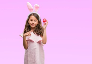 Paskalya tavşan kulakları el ve parmak ile tarafına işaret çok mutlu giyen esmer Latin kız