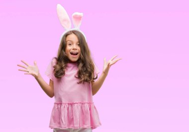 Esmer Latin kız kocaman bir gülümseme ile çığlık zaferini kutluyor ve ellerini kaldırdı Paskalya tavşan kulakları çok mutlu ve heyecanlı, kazanan ifade giyiyor