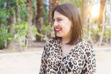 Bahçede mutlu gülümseyen kırmızı dudaklı genç güzel kadın