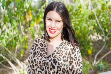 Bahçede mutlu gülümseyen kırmızı dudaklı genç güzel kadın