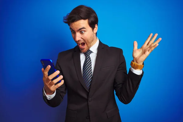 Junger Gutaussehender Geschäftsmann Mit Smartphone Vor Isoliertem Blauen Hintergrund Sehr — Stockfoto