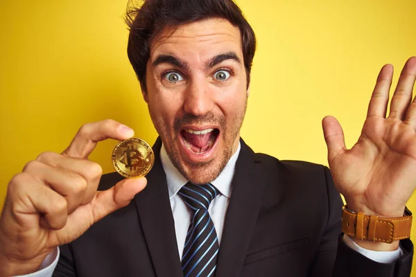 Νέος Όμορφος Επιχειρηματίας Κρατώντας Bitcoin Στέκεται Πάνω Από Απομονωμένο Κίτρινο — Φωτογραφία Αρχείου