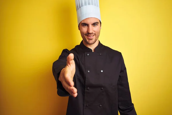 Mladý Kuchař Uniformě Klobouku Stojí Nad Osamělým Žlutým Pozadím Přátelsky — Stock fotografie