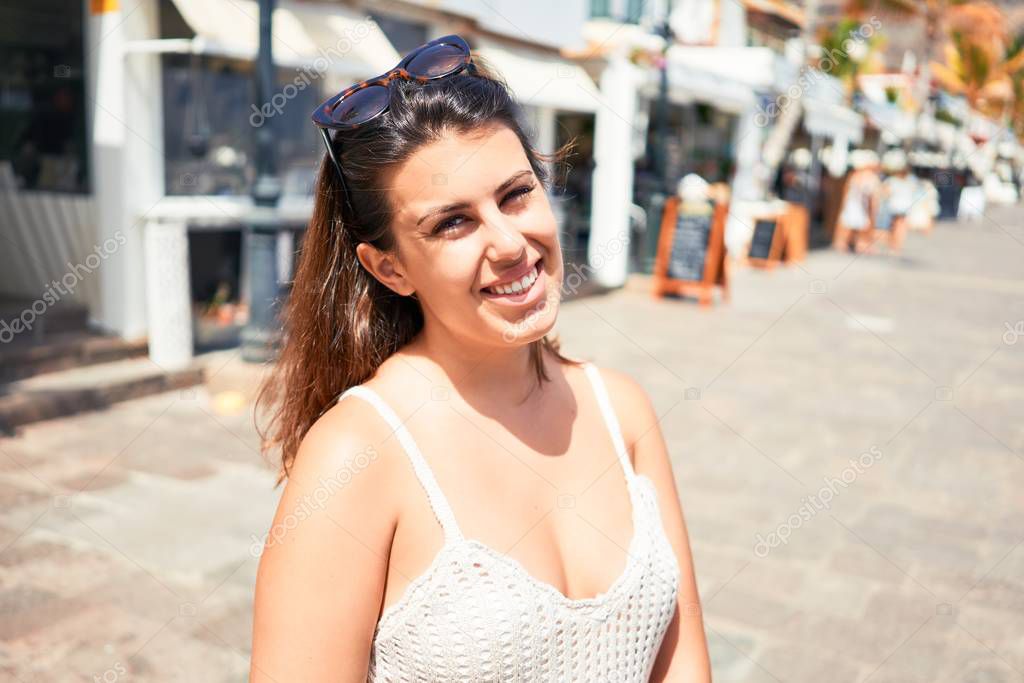 Young beautiful woman at the colorful village of Puerto de Mogan, smiling happy at the street on summer holidays