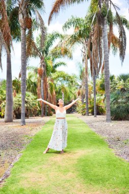 Güneşli bir yaz gününde yeşil parkta mutlu ve neşeli gülümseyen güzel bir kadın.