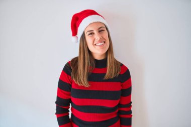 Gülümseyen güzel bir kadın çizgili süveter ve Noel Baba şapkası giyiyor.