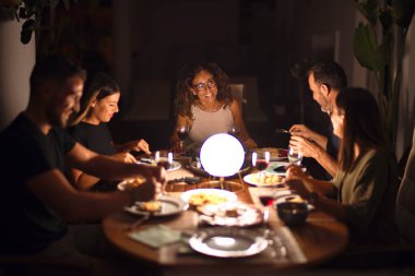 Güzel bir aile akşam yemeğinde terasta konuşuyor ve gülümsüyor